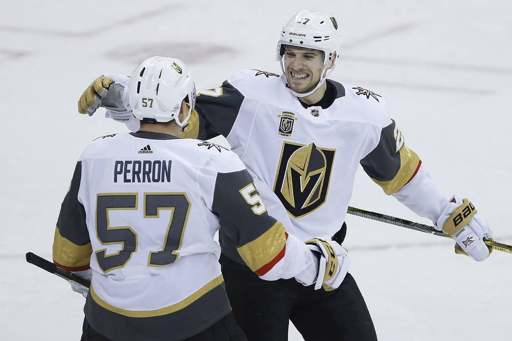 Vegas Golden Knights' David Perron (57) and Shea Theodore (27) celebrate Perron's overtime goal against the Winnipeg Jets during an NHL hockey game Thursday, Feb. 1, 2018, in Winnipeg, Manitoba. ( ...