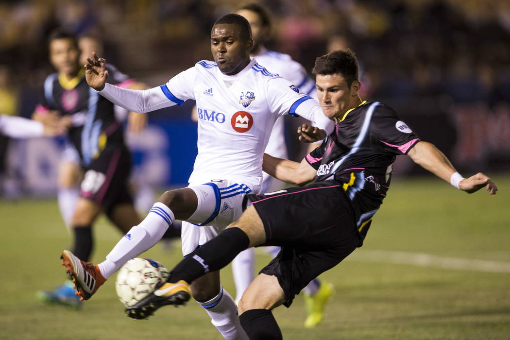 Las Vegas Lights FC Marcelo Thomas Matt (21) kicks the ball with pressure from Montreal Impact’s Chris Duvall (18)  during the exhibition match at Cashman Field in Las Vegas, Saturday, Feb. ...