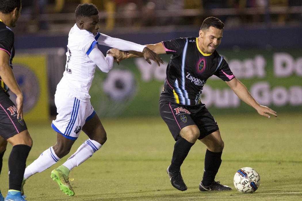 Montreal Impact's Cle´ment Bayiha (92) fights for the ball against and Las Vegas Lights FC Marcelo Julian Portugal (26) during the exhibition match at Cashman Field in Las Vegas, Saturday, Fe ...