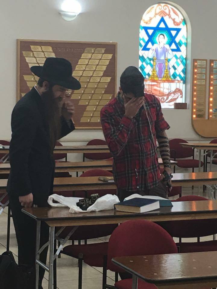 Shimon Abta wraps tefillin, Jewish prayer boxes, with his rabbi in Las Vegas on Jan. 8, 2017. Courtesy of Esther Abta.