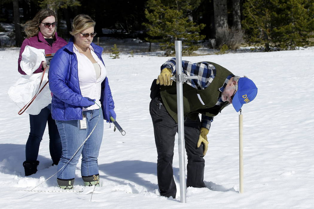 Frank Gehrke, right, chief of the California Cooperative Snow Surveys Program, for the Department of Water Resources, checks the snowpack depth as Courtney Obergfell, left, and Michelle Mead, cent ...