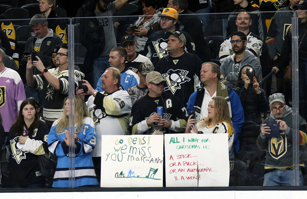 Pittsburgh Penguins fans hold up signs, one for Vegas Golden Knights goalie Marc-Andre Fleury (29), not pictured, prior to the start of NHL game at the T-Mobile Arena in Las Vegas, Thursday, Dec.  ...