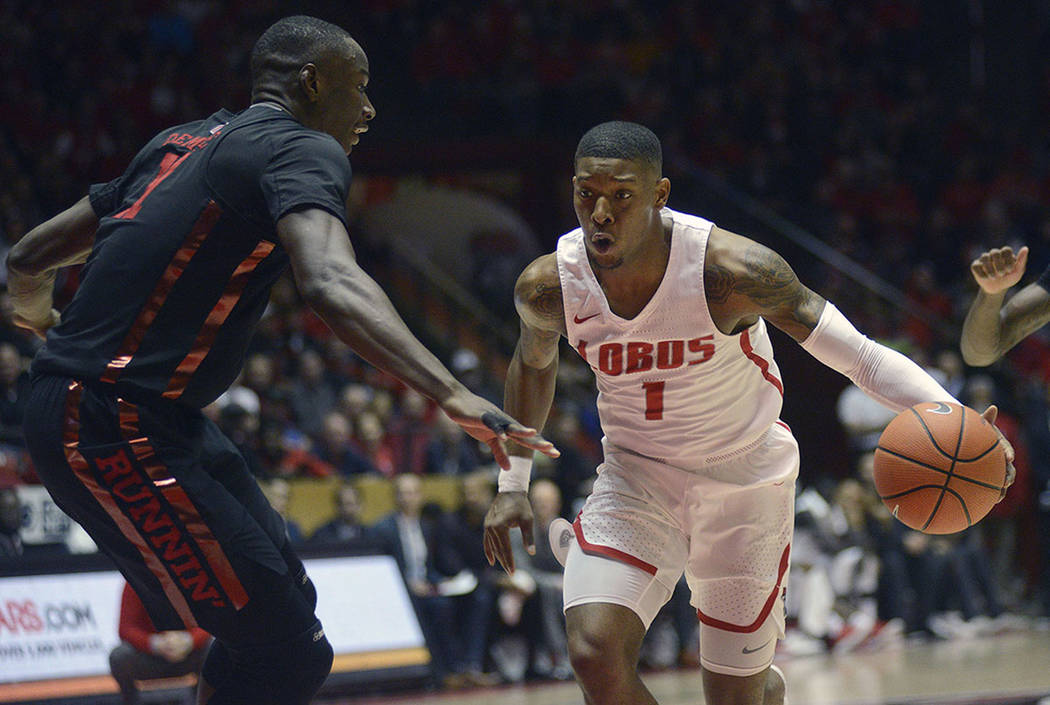 New Mexico's Chris McNeal, center, is defended by UNLV's Cheickna Dembele, left, and Kris Clyburn during an NCAA college basketball game Sunday, Feb. 25, 2018. (Adolphe Pierre-Louis/The Albuquerqu ...