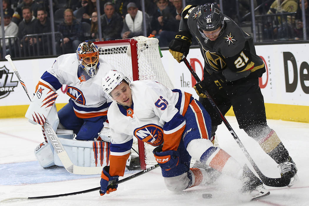 Golden Knights center Cody Eakin (21) tries to move the puck around New York Islanders center Tanner Fritz (56) during an NHL game at T-Mobile Arena in Las Vegas on Thursday, Jan. 25, 2018. Chase  ...