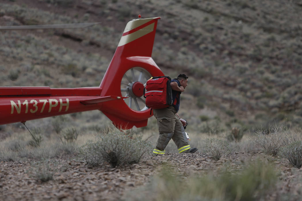 Emergency personnel go to the scene of a deadly tour helicopter crash in the Grand Canyon, Arizona, Saturday, Feb. 10, 2018. The crash killed three people and injured four others.  Photo by Teddy  ...