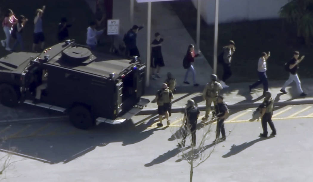 In this frame grab from video provided by WPLG-TV, students from the Marjory Stoneman Douglas High School in Parkland, Fla., evacuate the school following a shooting, Wednesday, Feb. 14, 2018. (WP ...
