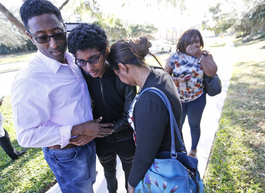 Family members embrace after a student walked out from Marjory Stoneman Douglas High School, Wednesday, Feb. 14, 2018, in Parkland, Fla. The shooting at the South Florida high school sent students ...
