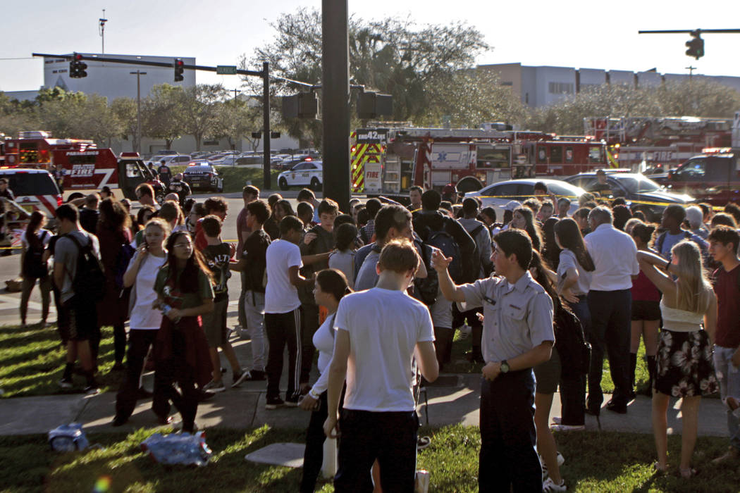 Students are released from a lockdown following a shooting at Marjory Stoneman Douglas High School in Parkland, Fla., on Wednesday, Feb. 14, 2018. (John McCall/South Florida Sun-Sentinel via AP)