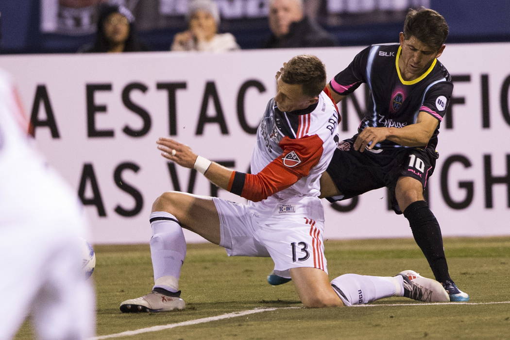 D.C. United's Frédéric Brillant (13) and Las Vegas Lights FC’s Juan Jose Calderon (10) collide going to the ball during the first half of the exhibition soccer game at Cashman Fie ...