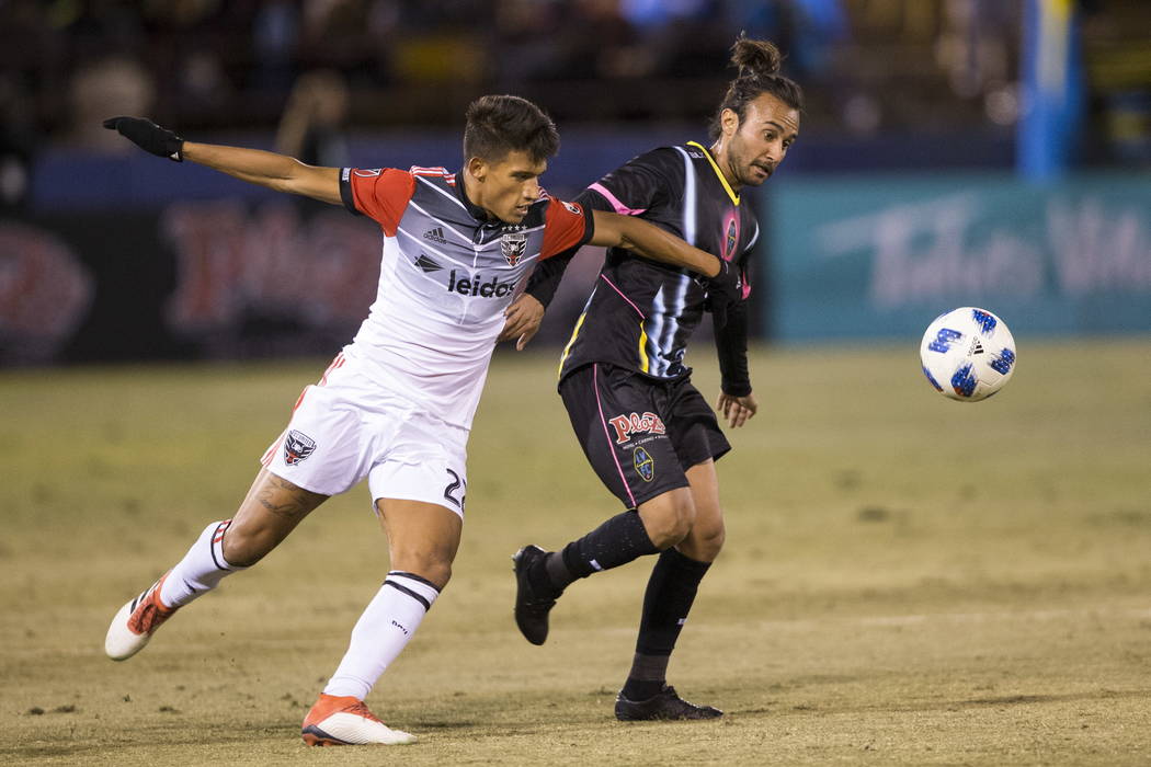 D.C. United's Yamil Asad (22) fights for the ball with Las Vegas Lights FC’s Isaac Diaz (8) during the first half of the exhibition soccer game at Cashman Field in Las Vegas, Saturday, Feb. ...