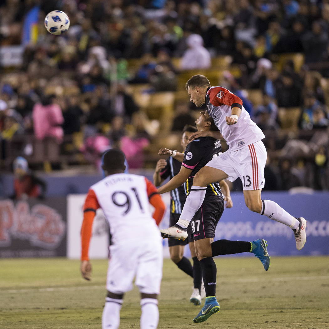 Las Vegas Lights FC’s  Samuel Ochoa (37) and D.C. United Frédéric Brillant (13) leap for the ball during the first half of the exhibition soccer game at Cashman Field in Las Vegas ...