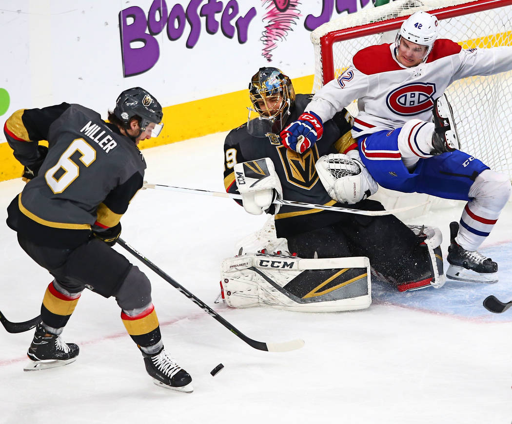 Montreal Canadiens center Byron Froese (42) falls onto Golden Knights goaltender Marc-Andre Fleury (29) as Golden Knights defenseman Colin Miller (6) goes for the puck during an NHL hockey game at ...