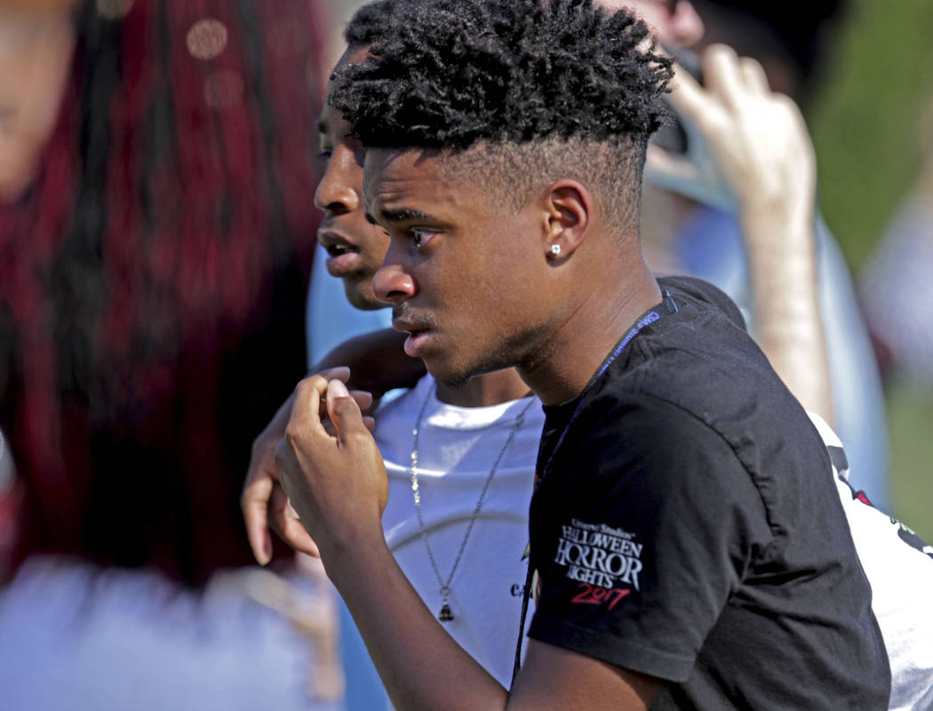 Students released from a lockdown walk away following a shooting at Marjory Stoneman Douglas High School in Parkland, Fla., on Wednesday, Feb. 14, 2018. (John McCall/South Florida Sun-Sentinel via AP)