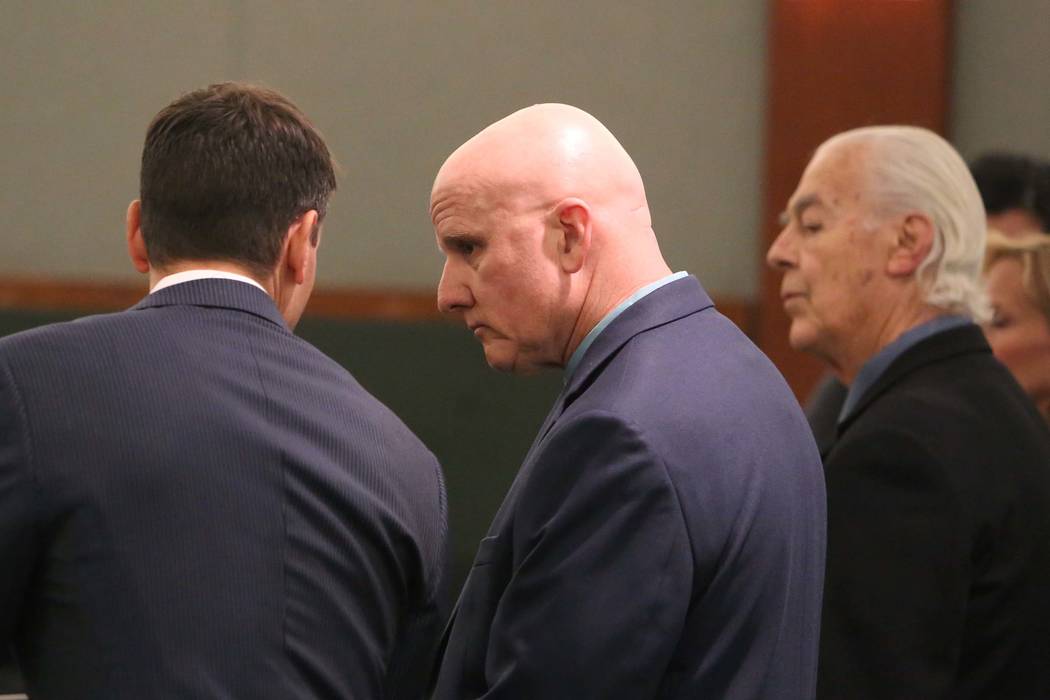 Las Vegas Metro Police officer, Lt. James Melton, center, appears in court at the Regional Justice Center on Wednesday, Feb. 21, 2018, in Las Vegas. Melton faces 14 felony counts, including theft, ...