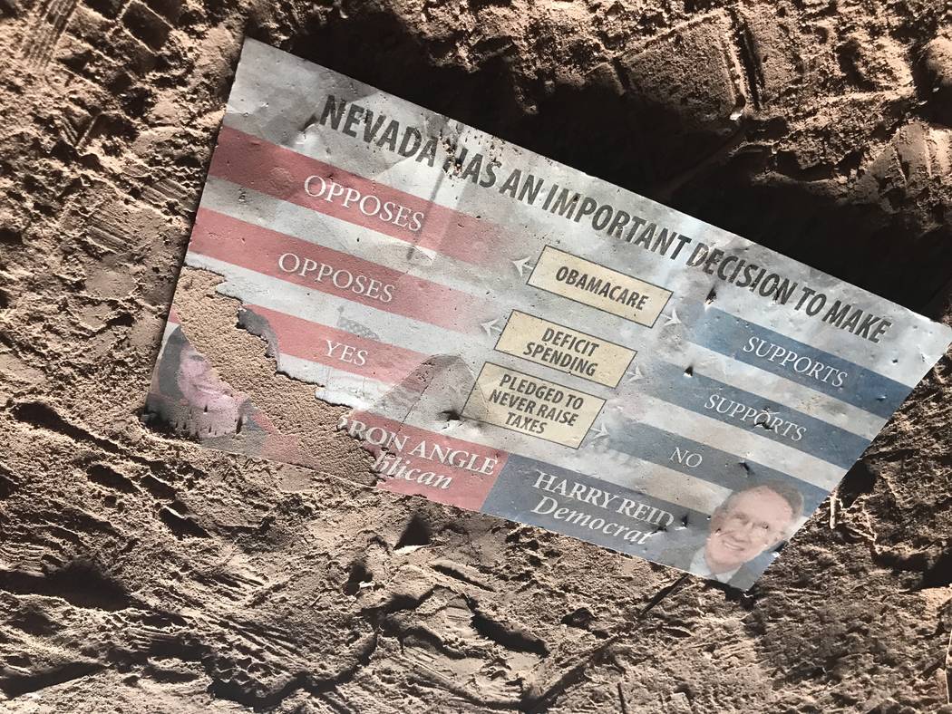 A campaign mailer from then-Sen. Harry Reid's 2010 senate race collects dust on the floor of an abandoned mine shaft near Fort Apache and Warm Springs roads on Wednesday, Feb. 21, 2018. (Henry Br ...