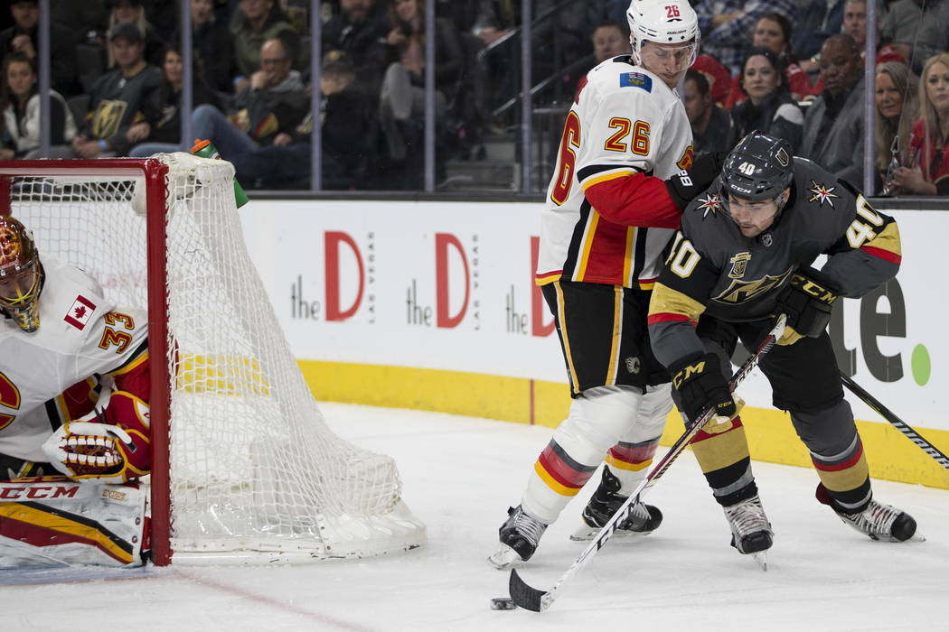 Vegas Golden Knights center Ryan Carpenter (40) looks for an open shot against pressure from Calgary Flames defenseman Michael Stone (26)during the first period of an NHL game at T-Mobile Arena i ...