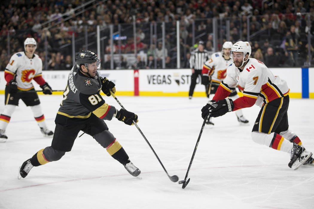 Vegas Golden Knights center Jonathan Marchessault (81) shoots the puck against pressure from Calgary Flames defenseman TJ Brodie (7) during the first period of an NHL game  at T-Mobile Arena in La ...