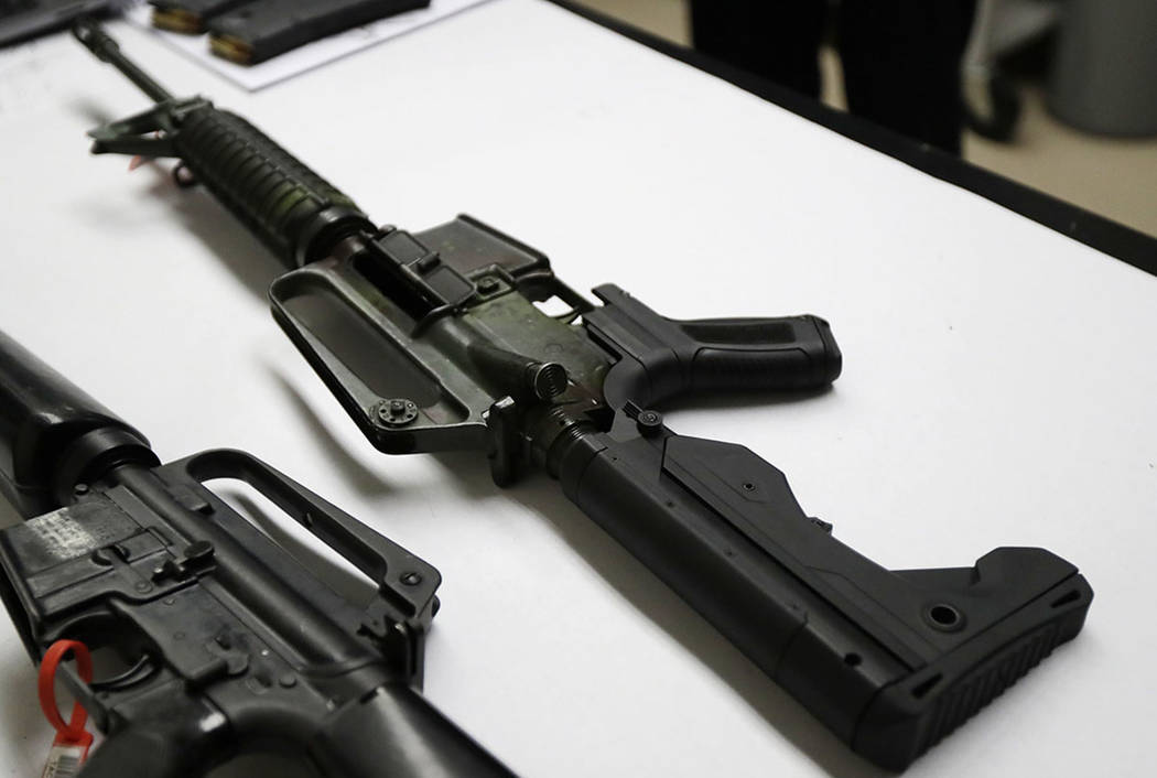 A semi-automatic rifle, at right, that has been fitted with a bump stock device sits on a table at the Washington State Patrol crime laboratory in Seattle. (AP Photo/Ted S. Warren)