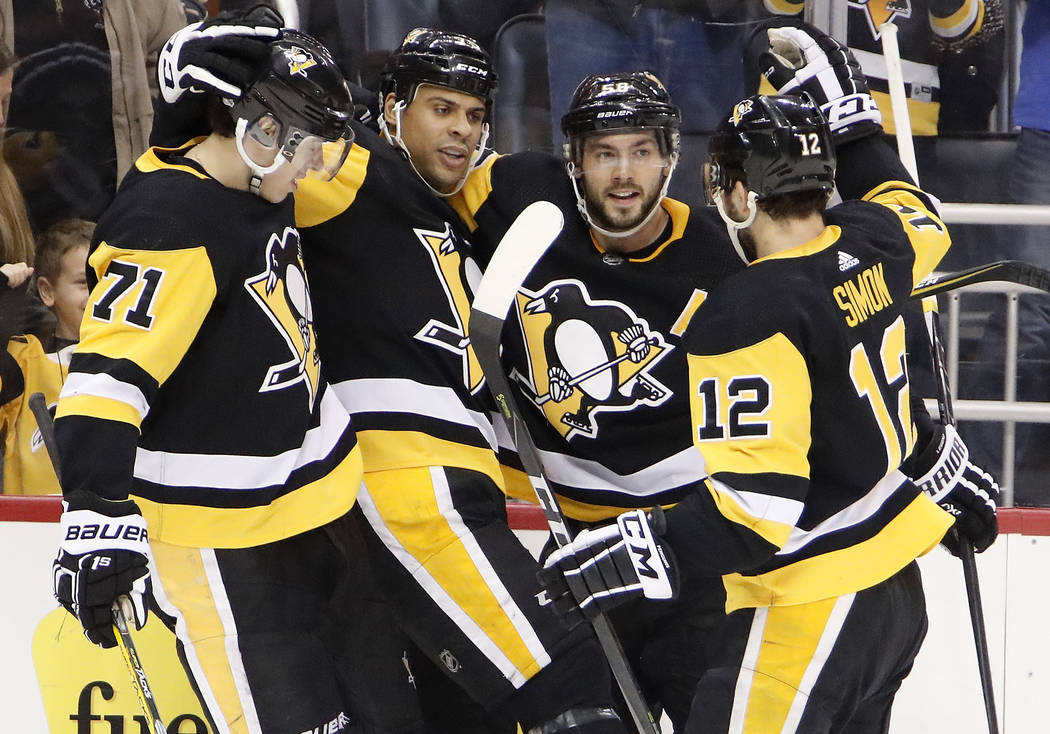 Pittsburgh Penguins' Dominik Simon, left, celebrates a goal by