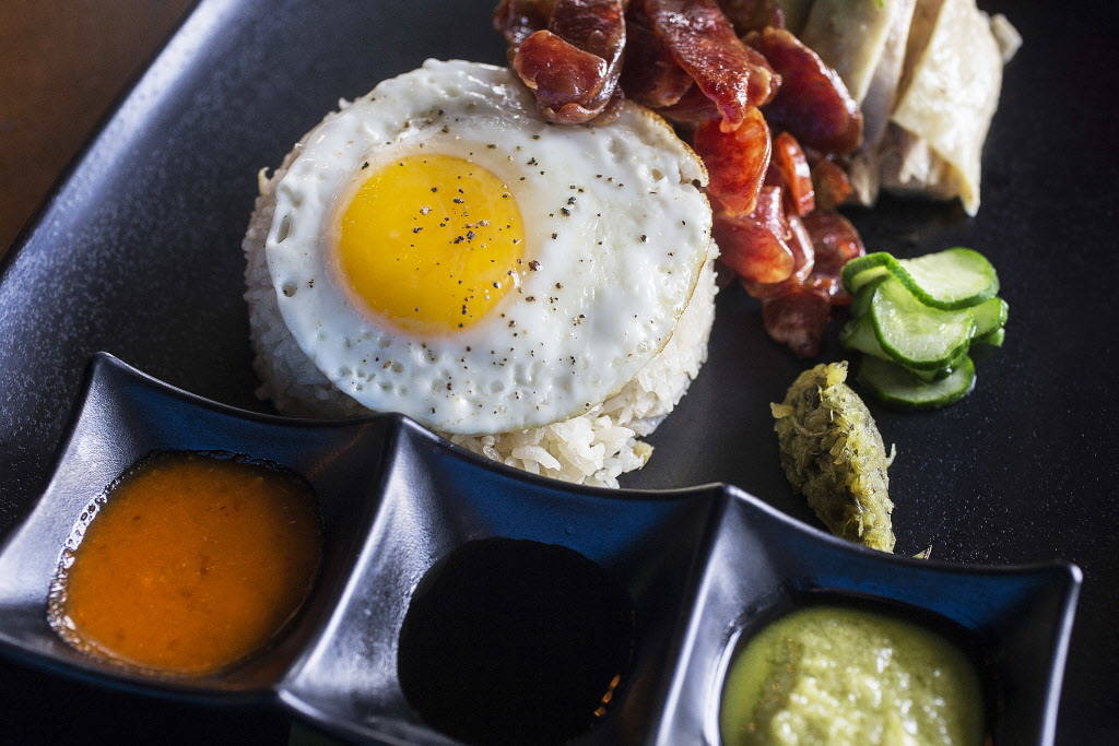 Hainanese chicken rice with Mary's free range chicken, chicken schmaltz rice, organic fried egg, Chinese sausage, cucumbers,, pickled mustard, greens, ginger scallion sauce, house made chili and h ...