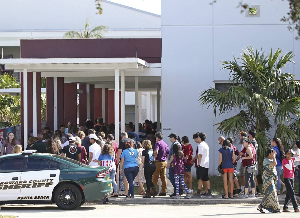 Parents and students walk into Marjory Stoneman Douglas High School on Sunday, Feb. 25, 2018, for an open house as parents and students returned to the school for the first time since 17 victims w ...