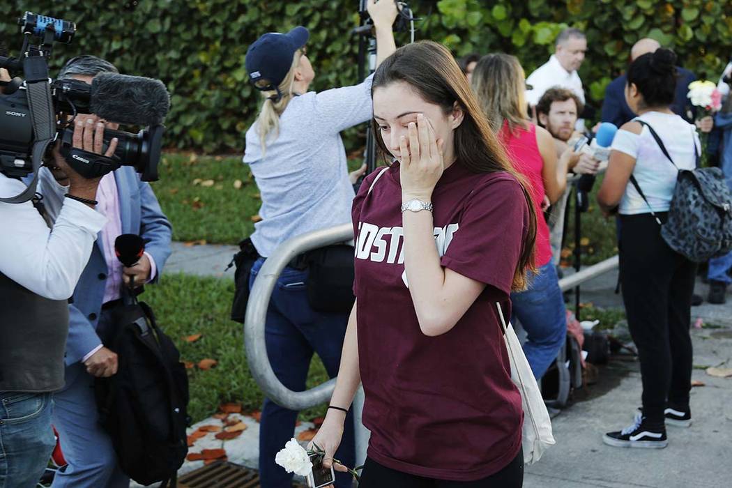 A student walks past the media at Marjory Stoneman Douglas High School in Parkland, Fla., Wednesday, Feb. 28, 2018. Students returned to class for the first time since 17 people were killed on Feb ...