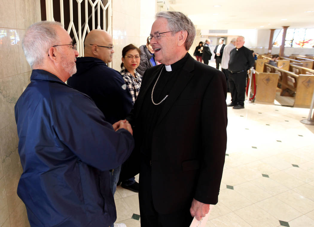 Bishop George Leo Thomas of the Diocese of Helena visits with John Ramos at Guardian Angel Cathedral Wednesday, Feb. 28, 2018, after he was introduced as the new bishop of the Roman Catholic Dioce ...