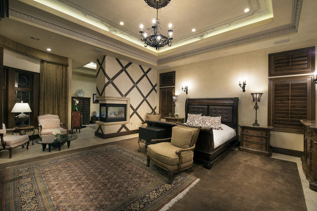 The large master suite has a three-sided fireplace. (Synergy/Sotheby’s International Realty)