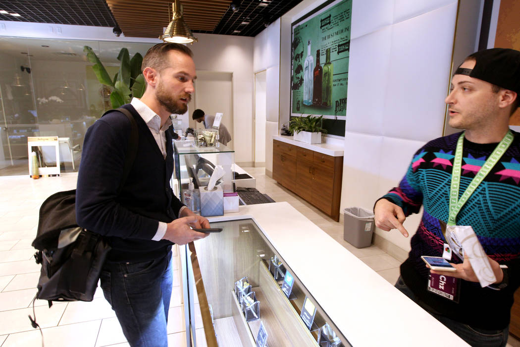 Gabriel Allred, co-founder of Tokes Platform, left, uses his cryptocurrency to make a purchase with budtender Patrick Murphy at Pisos dispensary, at 4110 S. Maryland Pkwy. in Las Vegas Monday, Jan ...