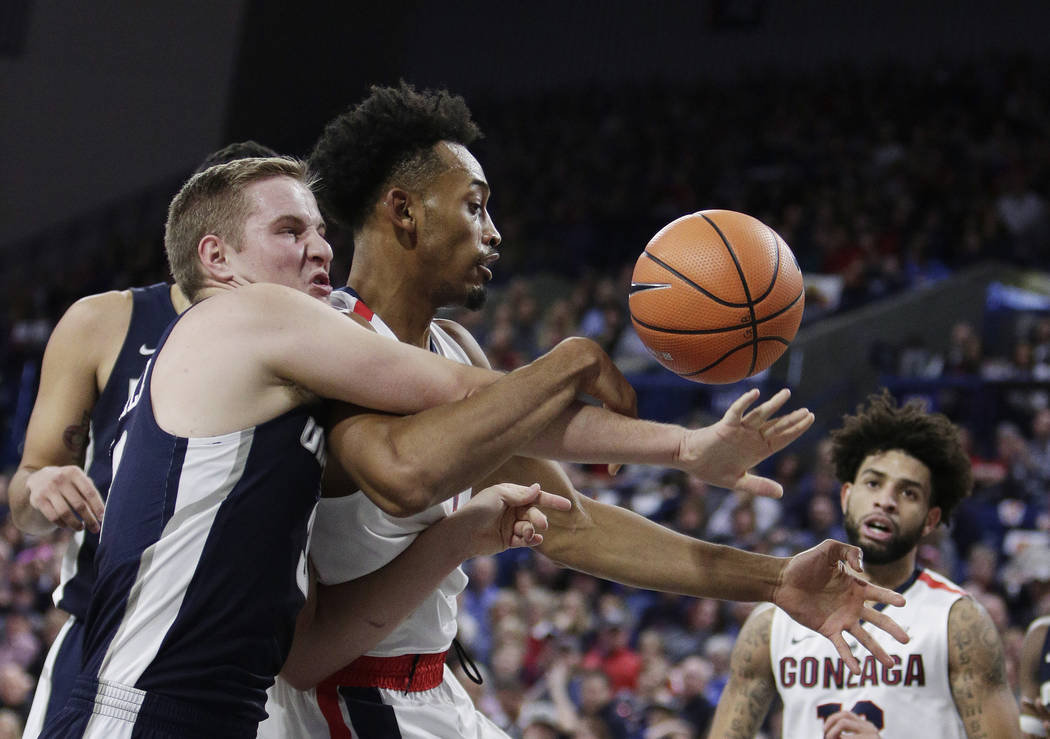 Utah State guard Sam Merrill, left, and Gonzaga forward Johnathan Williams go after a rebound during the first half of an NCAA college basketball game in Spokane, Wash., Saturday, Nov. 18, 2017. ( ...