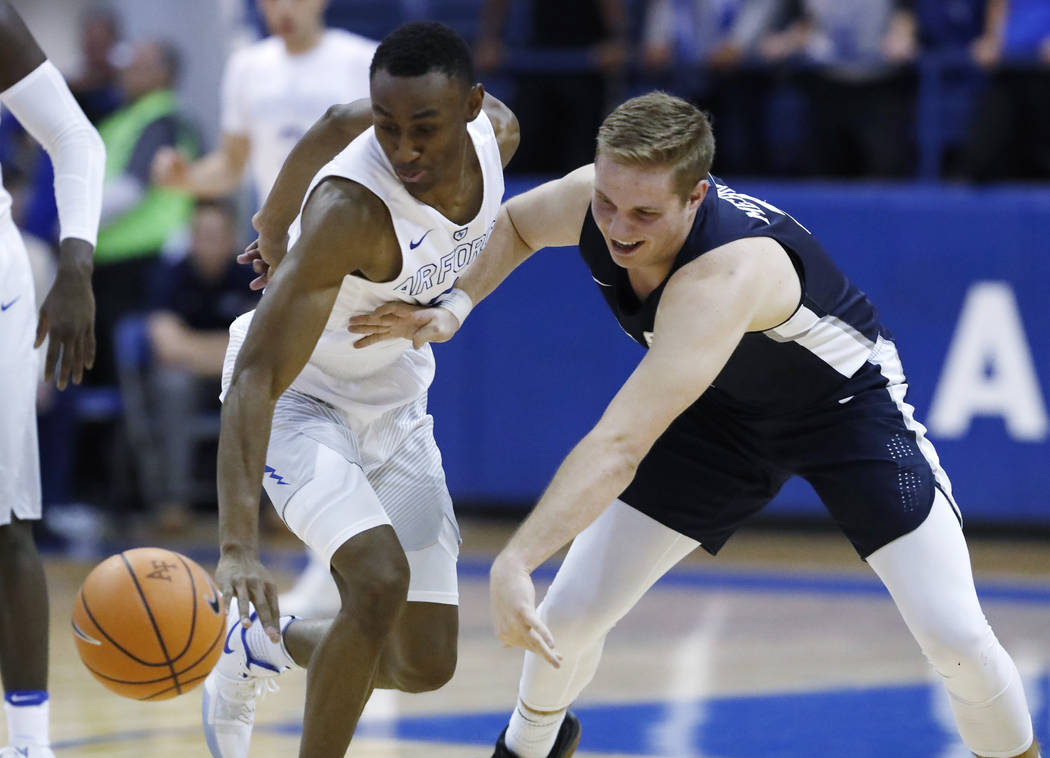 Air Force guard CJ Siples, left, knocks the ball away from Utah State guard Sam Merrill in the second half of an NCAA college basketball game Saturday, Feb. 24, 2018, at Air Force Academy, Colo. ( ...