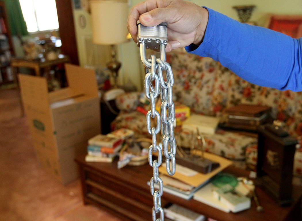 A neighbor show a chain that was cut from a gate at a home at 809 Palmhurst Drive in Las Vegas Thursday, Feb. 22, 2018. After home owner Carole Barnish died last August, Shalena Earnheart claimed  ...