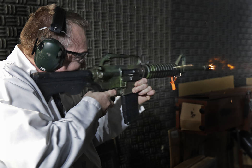Washington Rick Wyant, supervisor of the forensic firearms unit at the Washington State Patrol crime laboratory in Seattle, test fires a semi-automatic rifle that has been fitted with a so-called ...