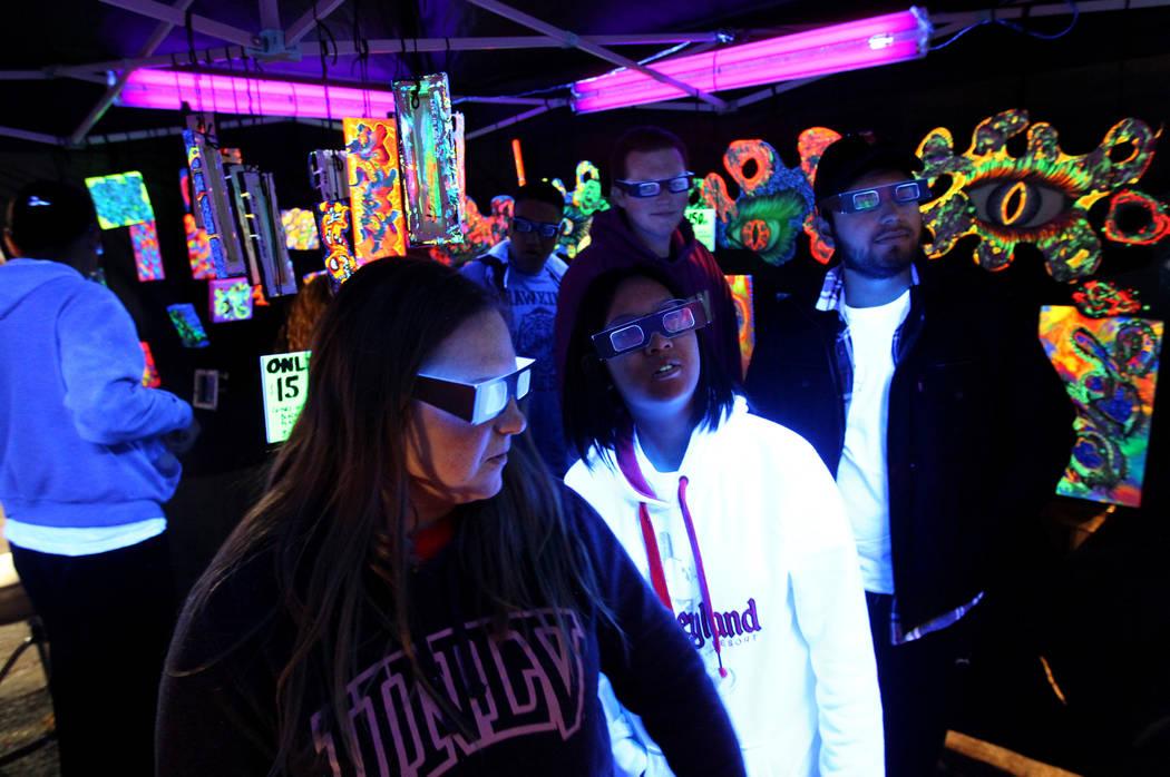 Natalie Rea, from left, Emerald Liu, Cody Hennessy and Victor Chavez check out 3D art at the Partners and Paint booth during First Friday in downtown Las Vegas' arts district Friday, March 2, 2018 ...