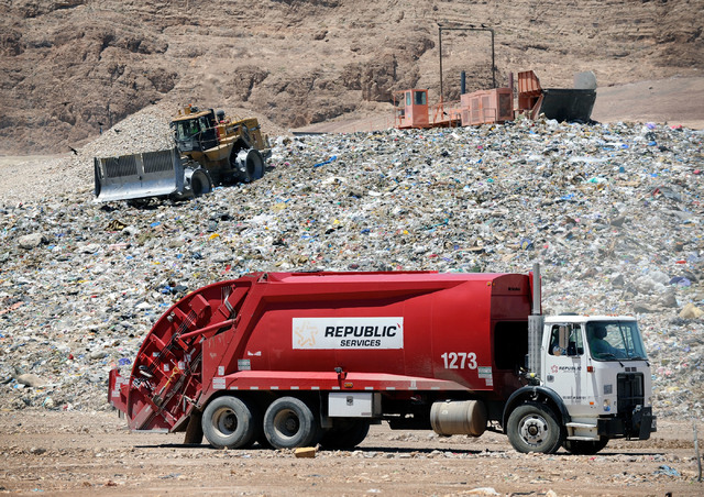 A trash truck arrives as workers use heavy equipment to push the rubbish at the Apex Regional Landfill on Thursday, May 17, 2012.  Republic Services has partnered with Energenic to build the new A ...
