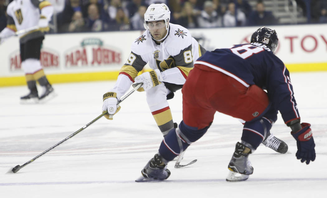 Las Vegas Golden Knights' Alex Tuch, left, looks for an open pass as Columbus Blue Jackets' David Savard defends during the first period of an NHL hockey game Tuesday, March 6, 2018, in Columbus,  ...