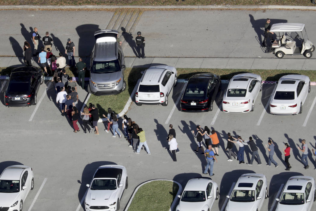 Students are evacuated by police from Marjory Stoneman Douglas High School in Parkland, Fla., after a shooter opened fire on the campus on Feb. 14, 2018. (Mike Stocker/South Florida Sun-Sentinel v ...