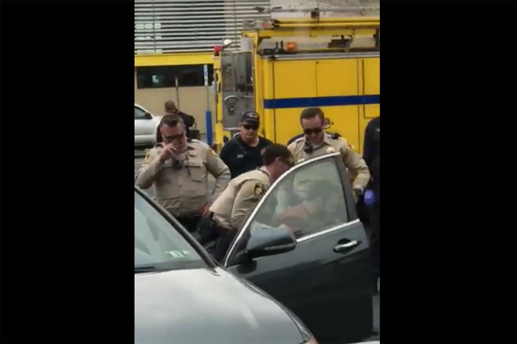 Images taken from a video by Steven Gibson of Las Vegas police arresting a man who was found unconscious in his car with a semi-automatic rifle and extra ammunition. (Steven Gibson/Facebook)