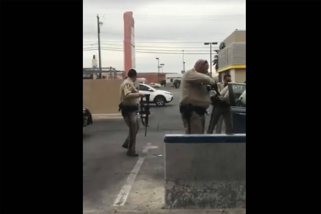 Images taken from a video by Steven Gibson of Las Vegas police arresting a man who was found unconscious in his car with a semi-automatic rifle and extra ammunition. (Steven Gibson/Facebook)