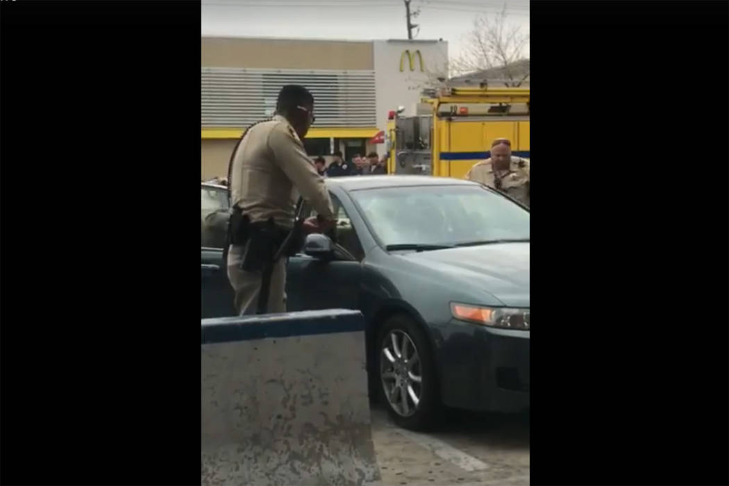 Images taken from a video by Steven Gibson of Las Vegas police arresting a man who was found unconscious in his car with a semi-automatic rifle and extra ammunition. (Steven Gibson/Facebook)