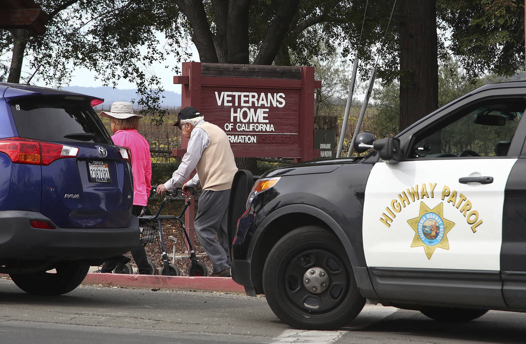 People walk to the information center at the Veterans Home of California in Yountville, Calif., on Friday March 9, 2018. A gunman took at least three people hostage at the largest veterans home in ...