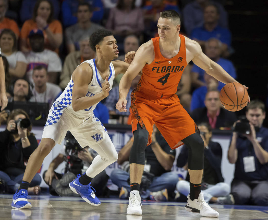 Florida guard Egor Koulechov (4) dribbles against the defense by Kentucky guard Quade Green (0) during the second half of an NCAA college basketball game in Gainesville, Fla., Saturday, March 3, 2 ...