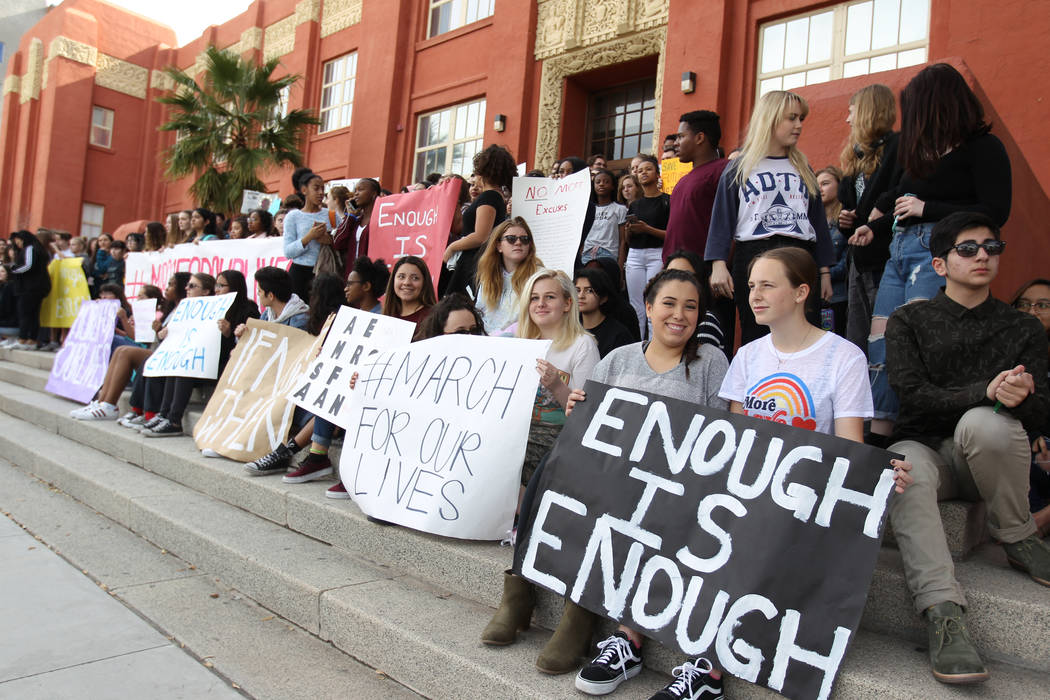 Students at Las Vegas Academy sit on the steps at the entrance to the school after walking out of class Wednesday, March 14, 2018, to mark the one-month anniversary of a shooting at a Florida scho ...