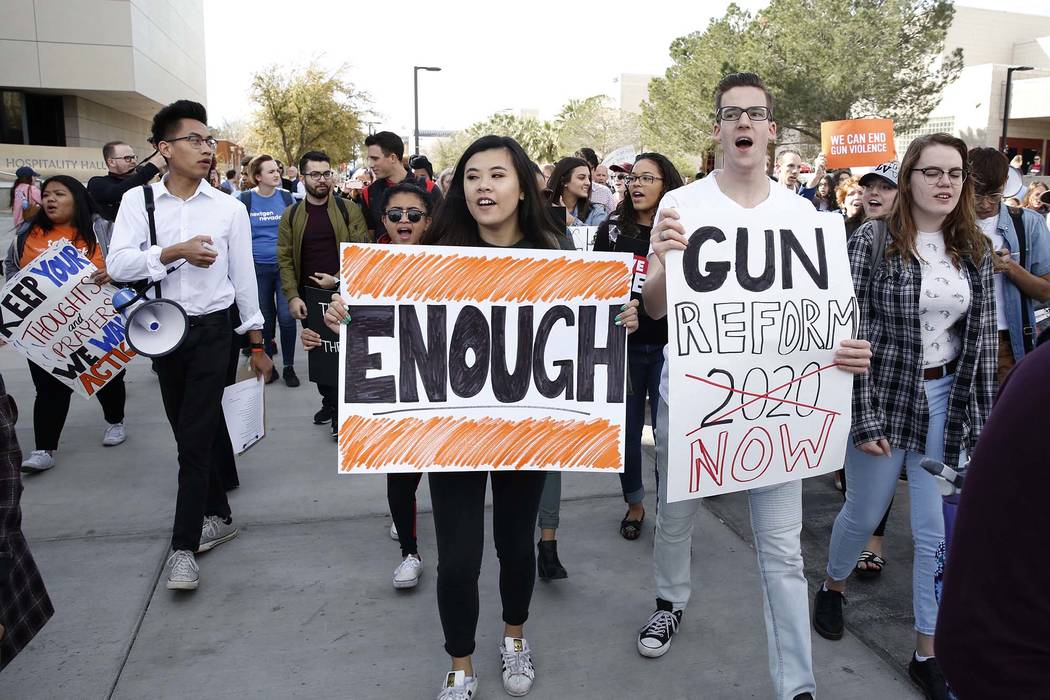 UNLV students, including Karl Catarata, second left, Tiffany Alm, center, and Aron Csiki shout slogans as they march on campus in Las Vegas on Wednesday, March 14, 2018, as part of a nationwide p ...