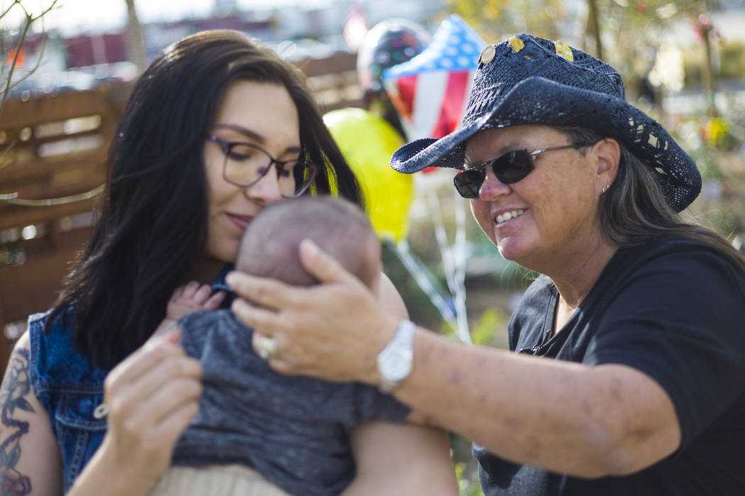 Oct. 1 shooting survivor Sue Ann Cornwell, right, talks with infant Xander Finch whose mother Miriam Lujan, left, was rescued by Cornwell at the Route 91 festival. They reunited while visiting the ...