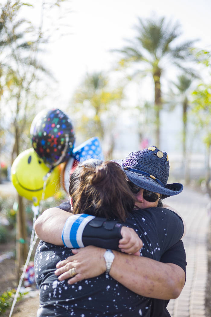 Oct. 1 shooting survivor Sue Ann Cornwell, right, hugs fellow survivor Cynthia Velez at the Community Healing Garden in downtown Las Vegas on Friday, March 9, 2018. Cornwell and Lujan were visitin ...