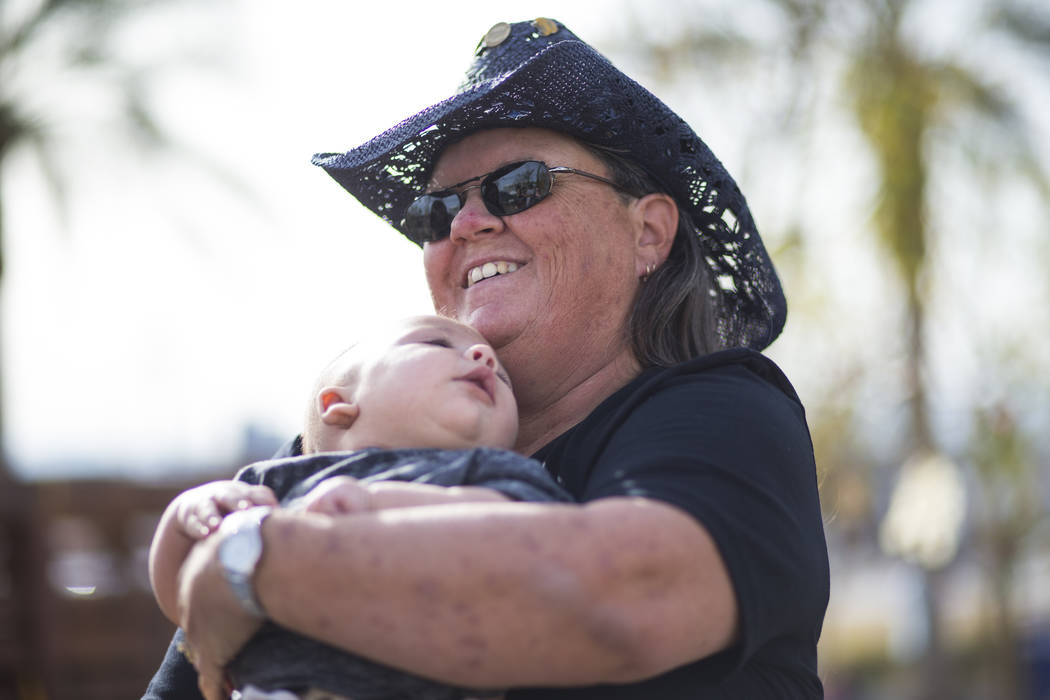 Oct. 1 shooting survivor Sue Ann Cornwell, right, holds infant Xander Finch whose mother Miriam Lujan, not pictured, was rescued by Cornwell at the Route 91 festival, while visiting the Community  ...