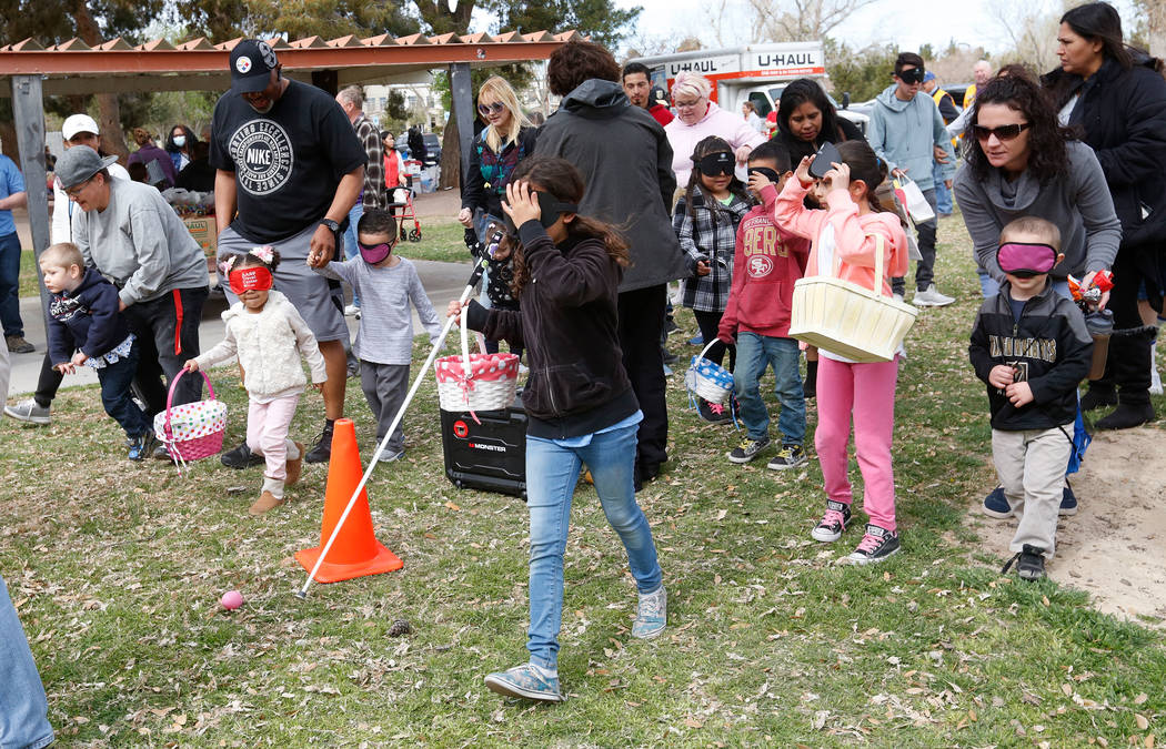 Children with visual impairments and their families look for beeping eggs during the Beepin' Egg Hunt at Sunset Park in Las Vegas, Saturday, March 24, 2018. Nevada Blind Children's Foundation host ...