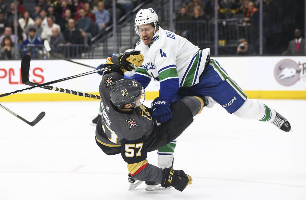 Vancouver Canucks defenseman Michael Del Zotto (4) knocks down Golden Knights left wing David Perron (57) during the first period of an NHL hockey game at T-Mobile Arena in Las Vegas on Tuesday, M ...