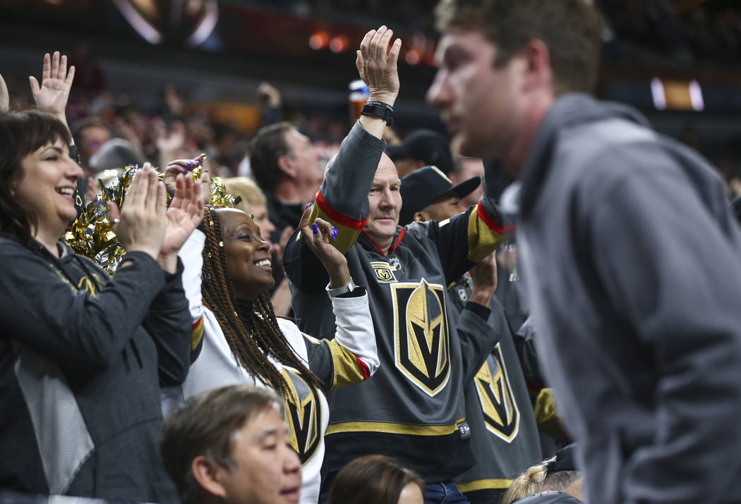 Golden Knights fans celebrate a goal by Golden Knights left wing Pierre-Edouard Bellemare, not pictured, against the Vancouver Canucks during the first period of an NHL hockey game at T-Mobile Are ...